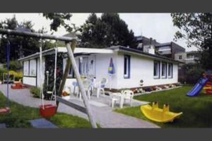 a house with a playground with a slide at Badehausallee 20 Bungalow in Cuxhaven