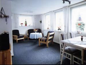 a room with a table and chairs and windows at Badehausallee 20 Bungalow in Cuxhaven