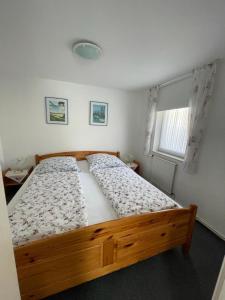 a bedroom with a wooden bed in a room with a window at Badehausallee 20 Bungalow in Cuxhaven