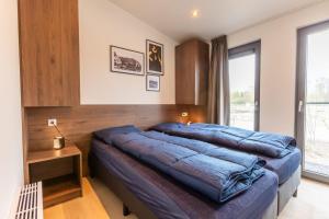 una camera da letto con due letti e una finestra di Cozy beach cottage Enkhuizen near the lake a Enkhuizen Altre 12 foto