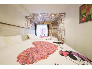 a bedroom with a bed with a flower rug on it at R Hotel - Vacation STAY 19690 in Chiba