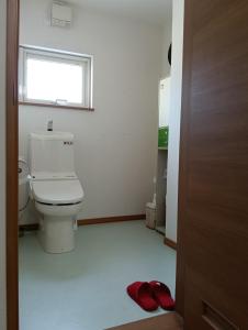 富良野市にあるOkufurano Lupine - Vacation STAY 19136のトイレと窓と赤いスリッパを備えたバスルーム
