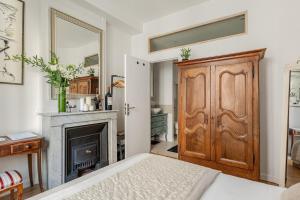 a bedroom with a wooden door and a fireplace at Nid de calme centrale climatisé in Lyon