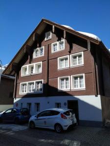 a white car parked in front of a building at Berni's in Andermatt