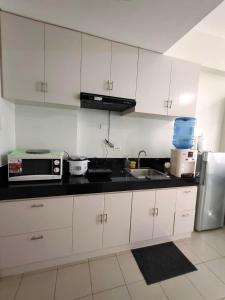 a kitchen with white cabinets and a black counter top at Hill Residence by Sarah Rentals in Manila