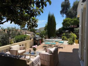 un patio con sillas, mesas y una parrilla en Magnifique studio entier avec terrasse Saint Jean Cap Ferrat, en Saint-Jean-Cap-Ferrat