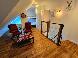 a living room with two chairs and a stair case at Glass Hill Apartament dwupoziomowy Karpacz z widokiem na góry 8 osób in Karpacz