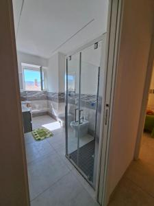 een badkamer met een glazen douche en een toilet bij APPARTAMENTO Dal Duca Enrico in Castelsardo