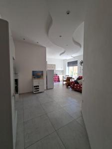 een woonkamer met witte muren en een grote tegelvloer bij APPARTAMENTO Dal Duca Enrico in Castelsardo