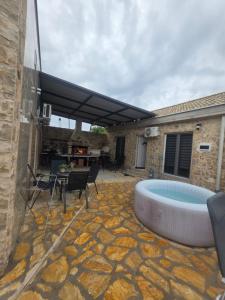 a patio with a hot tub and a table and chairs at App 3 Ville Adan in Donji Zemunik