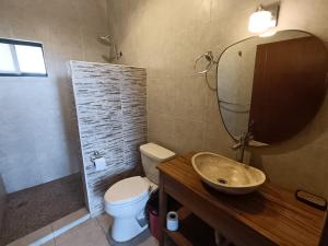 a bathroom with a sink and a toilet and a mirror at Abitare Mezcala Residencia in Isla de Mezcala +24 photos