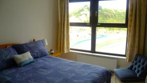 a bedroom with a bed and a window with a view of a pool at 9 Rock Towers in Looe