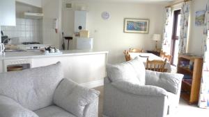 a living room with two chairs and a kitchen at 9 Rock Towers in Looe