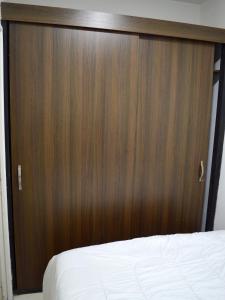 a bed with a large wooden headboard in a room at apartamento ambiente familiar y central in Estación El Salto