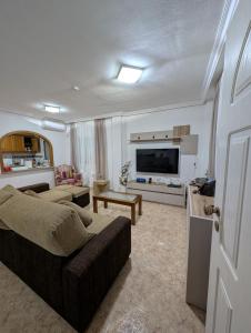 a living room with a couch and a flat screen tv at Casa Kave Euro Roda-Los Alcazares in Los Alcázares