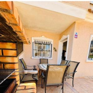 a patio with chairs and a table and a window at Casa Kave Euro Roda-Los Alcazares in Los Alcázares
