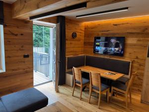 a dining room with a table and a tv on the wall at PEC 140 - apartmány Máj in Pec pod Sněžkou