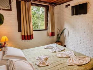 a bedroom with two beds with towels on them at Recanto Quinta da Jade in Itaipava +70 photos