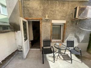a patio with three chairs and a table and a door at Sveji garden in Varna City