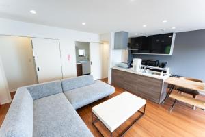 Una sala de estar con un sofá y una cocina. en GIFTHOUSE 2nd Ichinomiya - Small luxury villa - - Vacation STAY 19373, en Ichinomiya