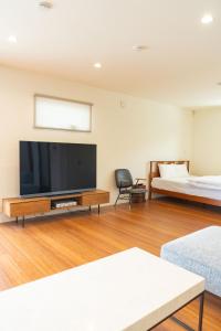 sala de estar con TV de pantalla plana y cama en GIFTHOUSE 2nd Ichinomiya - Small luxury villa - - Vacation STAY 19373, en Ichinomiya