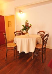 - une table à manger avec un vase de fleurs dans l'établissement Cellier de l'abbaye - L'Ermitage, à Vézelay