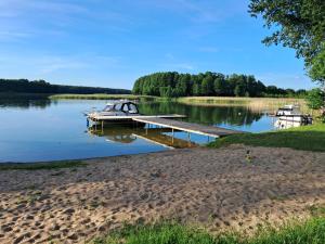 a boat is docked at a dock on a lake at Nad Zatoką pokoje z widokiem na jezioro in Ryn +7 photos