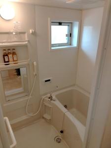 bagno bianco con vasca e finestra di Okumamachi Peony House 106 - Vacation STAY 19531 a Shimo-nogami