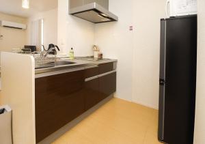 una cucina con un lavello e un frigorifero nero di Okumamachi Peony House 106 - Vacation STAY 19531 a Shimo-nogami Altre 7 foto