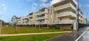 an apartment building with a parking lot in front of it at Beau T2 Arlesien in Arles