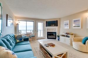 un salon avec un canapé bleu et une cheminée dans l'établissement M & M Beach Nest, à Rockaway Beach