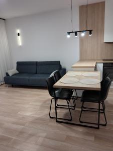 a kitchen with a table and chairs and a couch at Apartament Kameralny in Brodnica