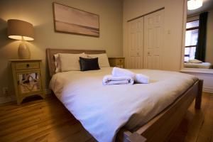 a bedroom with a large bed with towels on it at Le Metro Mont-Royal by HomeInMontreal in Montreal +17 photos