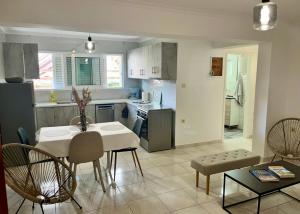 a kitchen and living room with a table and chairs at Poseidon's Rio Beach Condo in Vernardhaíika