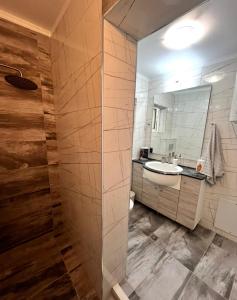 a bathroom with a sink and a shower at Poseidon's Rio Beach Condo in Vernardhaíika +19 photos