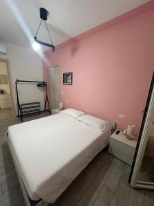 a bedroom with a white bed and a pink wall at Mare Palau Sardegna in Palau +13 photos