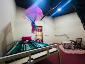 a bedroom with a bed with a pink umbrella at Hakuna Matata Hostel in Sigiriya