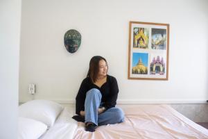 a woman sitting on top of a bed at Ocean Island Inn in Victoria