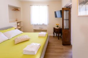 a bedroom with a yellow bed and a table at Corte di Raglio in Cunardo