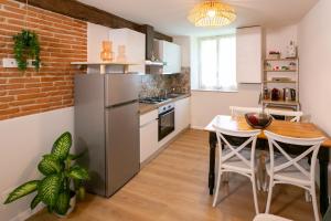 a kitchen with a wooden table and a refrigerator at Corte di Raglio in Cunardo