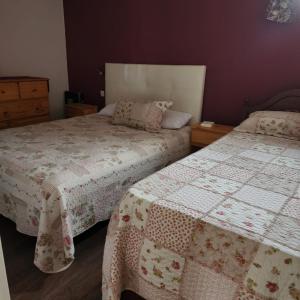 a bedroom with two beds with covers on them at Casaquinta Los Tilos Chascomus para 6 personas in Chascomús