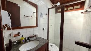 Un baño con lavabo, inodoro y espejo. en Pousada Casa Centro Búzios, en Búzios 47 fotos más