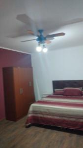 a bedroom with a ceiling fan and a bed at Casaquinta Los Tilos Chascomus para 6 personas in Chascomús