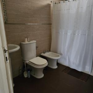a bathroom with a toilet and a sink at Casaquinta Los Tilos Chascomus para 6 personas in Chascomús
