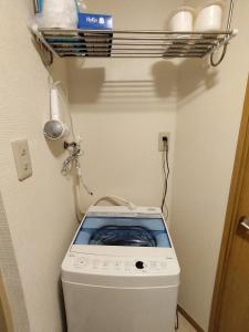 a washing machine in a bathroom with a shelf at Guesthouse Mulberry Kagoshima- Vacation STAY 50746v in Kagoshima