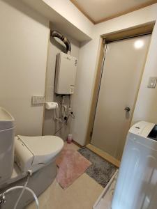 a bathroom with a toilet and a water heater at Guesthouse Mulberry Kagoshima- Vacation STAY 50746v in Kagoshima +6 photos