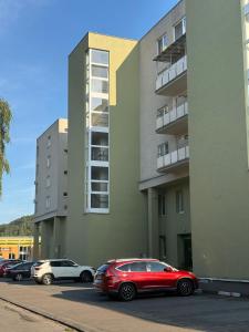 a red car parked in front of a building at LUX 3 bedroom apartman in Trenčín