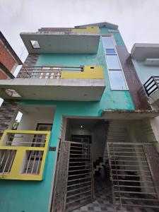 a blue building with yellow windows and stairs at Peaceful home stay 