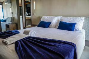 a large white bed with blue pillows and towels on it at Beira Mar Fortaleza Landscape in Fortaleza +21 photos