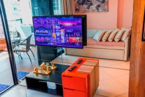 a living room with a tv and a couch at Beira Mar Fortaleza Landscape in Fortaleza